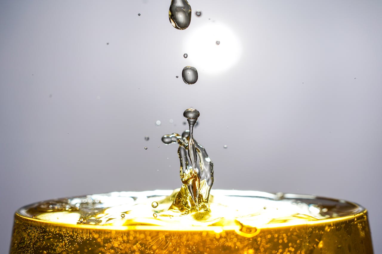 Dramatic close-up of golden liquid droplets suspended in mid-air, captured in vivid detail.